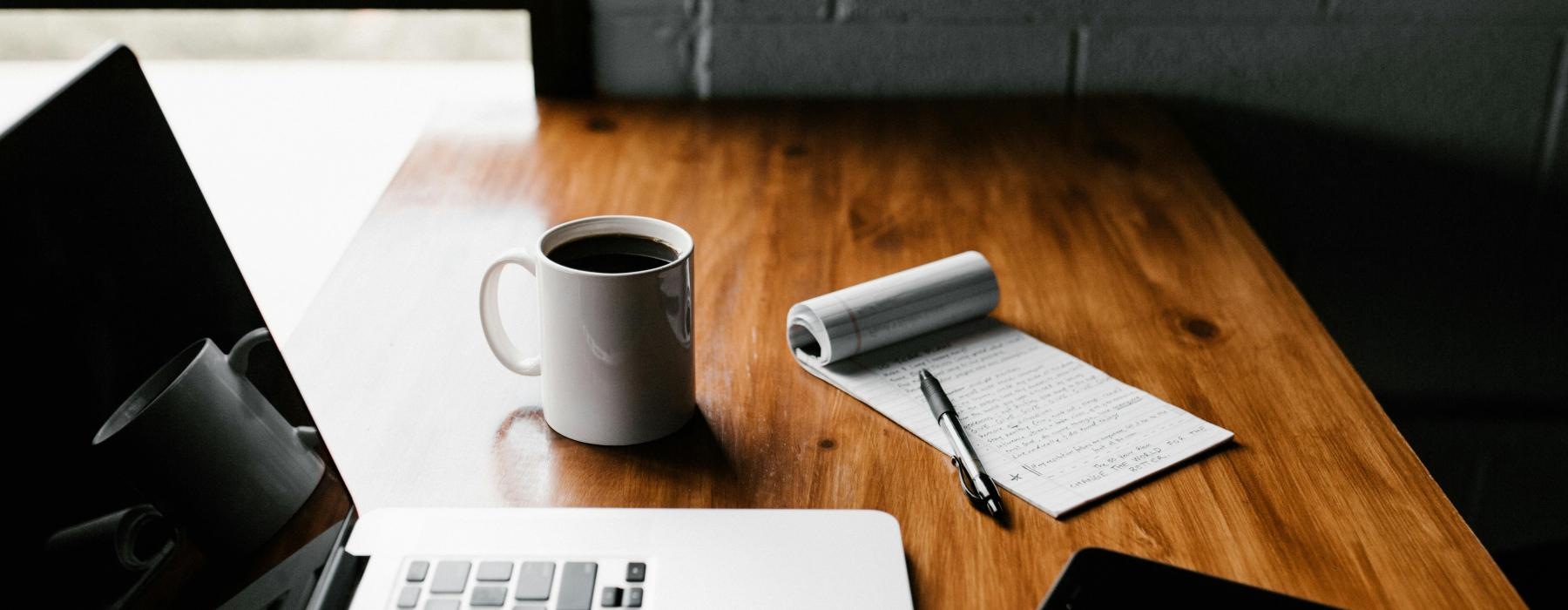 a laptop and a cup of coffee on a desk