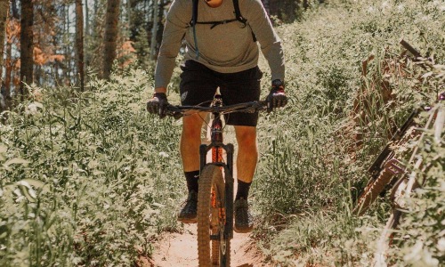 man riding a bike on a trail in the woods