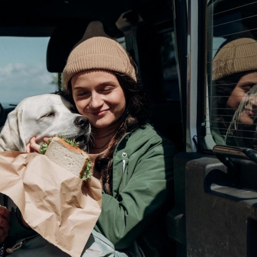 a man and woman eating food in a car