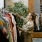 a person in a robe holding a plant in a room with a mirror