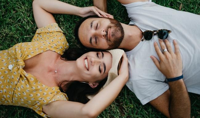 a man and woman lying in the grass